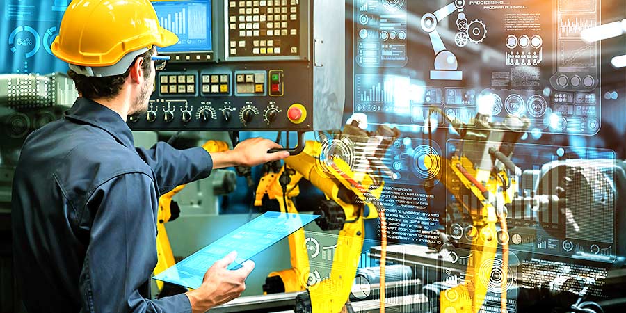 Das Bild zeigt einen Techniker, der mit seinem Laptop den Steuerungsprozess für einen kleinen Industrieroboter einrichtet. Es dient als Titelbild für das Thema „Smarte M&A für die Industrie 4.0.“.